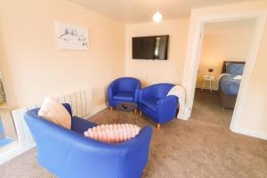 a living room with a blue couch and a bed at Captivating 1-Bed Apartment in Stroud in Stroud