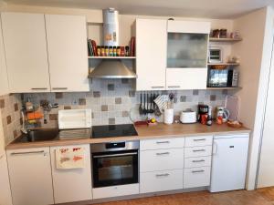 a kitchen with white cabinets and a stove top oven at Apartma Velesa in Rače