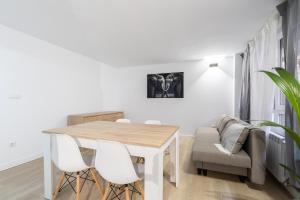 a white dining room with a table and white chairs at Boutique Palencia Pensión in Palencia
