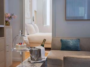 a living room with a bottle of champagne and a cake on a table at Elkonin Tel Aviv - MGallery Hotel Collection in Tel Aviv