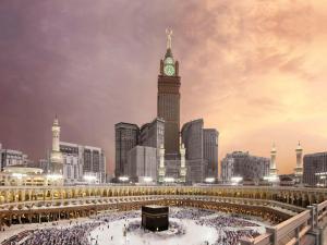 una torre dell'orologio in una città con una folla di persone di Makkah Clock Royal Tower, A Fairmont Hotel a La Mecca
