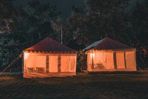 two tents are set up in a field at night at Shivika Lake Hotel Ranakpur in Sādri