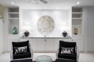 a living room with two chairs and a plate on the wall at White Horse Resort in Nusa Lembongan