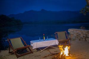 a table and two chairs around a campfire at Shivika Lake Hotel Ranakpur in Sādri
