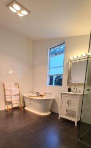 baño grande con bañera y lavamanos en The Cottage at Seppeltsfield, Barossa Valley en Seppeltsfield