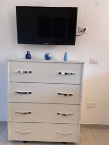 a dresser with a flat screen tv on top of it at CASA VACANZE ONDA BLU in Olbia