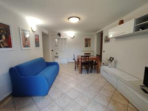 a living room with a blue couch and a table at Domus Laurenza in Acilia