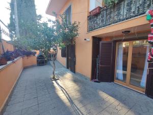 un árbol en una acera al lado de un edificio en Domus Laurenza, en Acilia