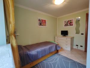 a bedroom with a bed and a dresser with a television at Domus Laurenza in Acilia