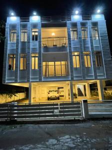 a car parked in front of a building at night at BMRAN Apartment R in Ernakulam