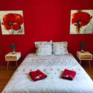 a red bedroom with a bed with two red pillows at Maison de ville rénovée au cœur du Cotentin. in Périers