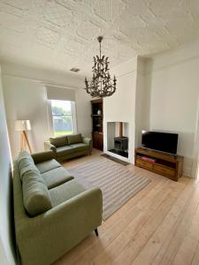 sala de estar con sofá y TV en The Cottage at Seppeltsfield, Barossa Valley en Seppeltsfield