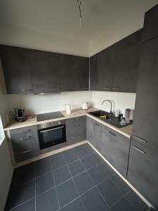 a kitchen with gray cabinets and a sink at Maison 2 chambres proche de Bruxelles in Mont-Saint-Guibert