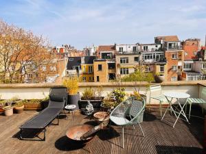 d'un balcon avec des chaises et des tables offrant une vue sur la ville. dans l'établissement Appartement 2 chambres grande terrasse centre de Bruxelles, à Bruxelles