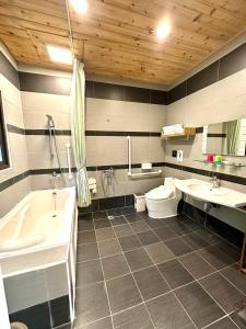 ein Badezimmer mit zwei Waschbecken, einer Badewanne und einem WC in der Unterkunft Li Wu Zuo Cun B&B in Chongde