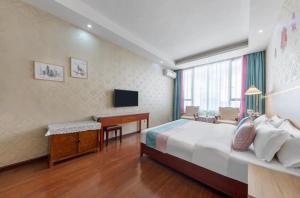 a hotel room with a large bed and a desk at Emeishan Hongzhao Hotel in Emeishan City