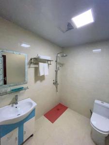 a bathroom with a sink and a toilet and a mirror at Emeishan Hongzhao Hotel in Emeishan City