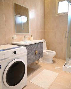 La salle de bains est pourvue d'un lavabo et d'un lave-linge. dans l'établissement 2 Bedroom Apartment in Jeddah, à Djeddah