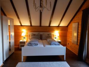 una camera da letto con un grande letto bianco con due lampade di Gemütliches Holzhaus in Gamlitz! a Gamlitz