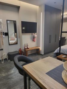 ein Wohnzimmer mit einem Tisch und einem TV an der Wand in der Unterkunft Modern studio in Veria center, near Elia square in Veria