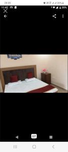 Una foto de un dormitorio con una cama con almohadas rojas en Prayas homestay, en Agra