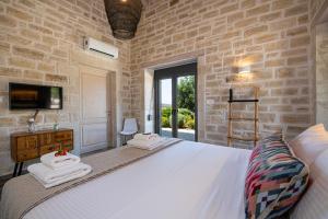a bedroom with a white bed and a tv at Villa PanSara Exclusive Luxury in Metochia Fratzeskiana