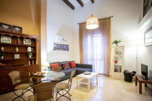 uma sala de estar com um sofá e uma mesa em WISH SUITE CALATRAVA DE SEVILLA em Sevilha