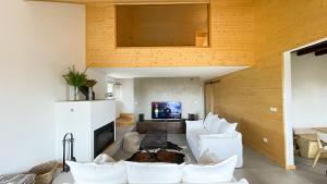 ein Wohnzimmer mit weißen Möbeln und einem TV in der Unterkunft Chalet Serra no Geopark Serra da Estrela - Gestão Donno in Penhas da Saúde
