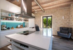 a kitchen with a white counter top and a chair at Villa PanSara Exclusive Luxury in Metochia Fratzeskiana