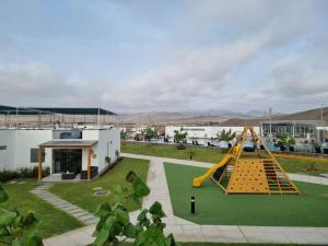 un parque infantil con un tobogán amarillo en un patio en Casa de Playa en Puerto Viejo, en San Antonio