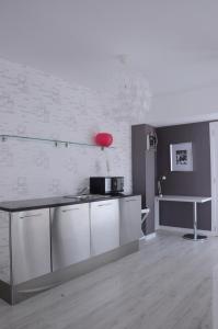 a kitchen with white cabinets and a counter top at Prassa 3 Boutique Hotel in Mindelo