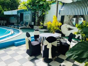 een patio met een tafel en stoelen naast een zwembad bij Hotel Mount Lanka in Watumulla