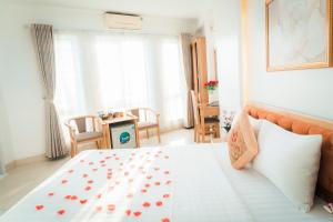 um quarto com uma cama grande com flores em Victoria Hotel Me Tri em Hanói