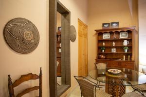 uma sala de jantar com uma mesa de vidro e um espelho em WISH SUITE CALATRAVA DE SEVILLA em Sevilha