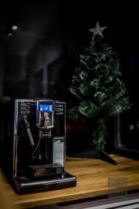 a coffee machine sitting on a table with a christmas tree at Elite Studio Apartament in Câmpulung Moldovenesc