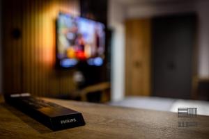 un mando a distancia sobre una mesa de madera en Elite Studio Apartament, en Câmpulung Moldovenesc