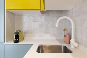 eine Küche mit einem Waschbecken und einem gelben Schrank in der Unterkunft Estudio moderno y acogedor en Madrid Rio nº4 in Madrid