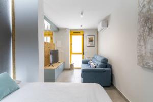 Habitación con cama, sofá y TV. en Estudio moderno y acogedor en Madrid Rio nº4 en Madrid