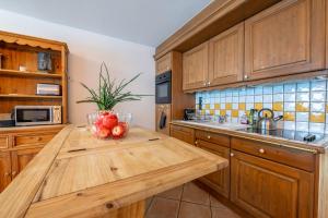 a kitchen with wooden cabinets and a wooden table with apples on it at Residence Bec in Chamonix +10 photos