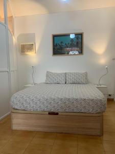 a bed in a bedroom with a picture on the wall at Apartamento en Los Cristianos Edificio Guayero in Los Cristianos
