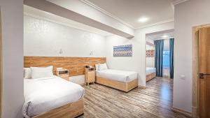 a hotel room with two beds and a window at Hotel Bankir Khiva in Khiva