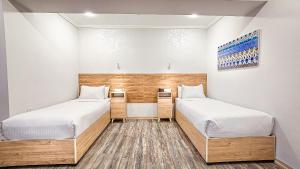 two beds in a room with white walls at Hotel Bankir Khiva in Khiva