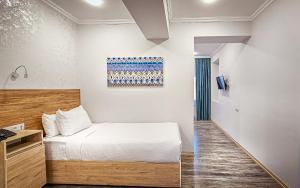 a bedroom with a bed and a painting on the wall at Hotel Bankir Khiva in Khiva