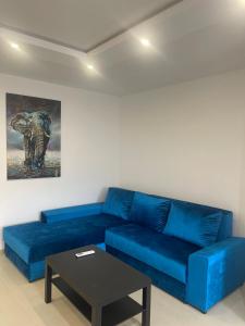 Sofá azul en la sala de estar con mesa en Twins, en Bečej