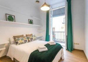a bedroom with a bed with green curtains and a window at Old Town y Beach Holirent in Alicante
