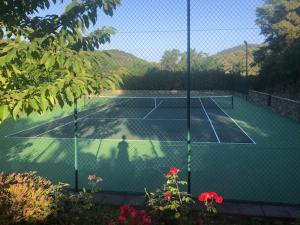 una pista de tenis con un tenista. en Molino Rio Alajar, en Alájar