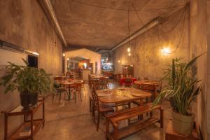un restaurante con mesas de madera, sillas y plantas en Babel, en Oporto