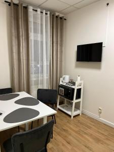 a dining room with a table and a tv at GLOW Apartment in Magdeburg