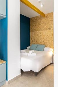 a bedroom with a white bed with blue walls at Estudio moderno y acogedor en Madrid Rio nº5 in Madrid
