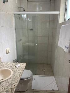 a bathroom with a shower with a toilet and a sink at Oscar Palace Hotel - Centro de Tubarão in Tubarão